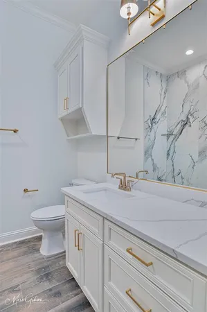 a bathroom with a granite countertop sink a toilet and a shower