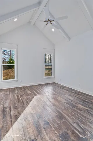 an empty room with windows and ceiling fan