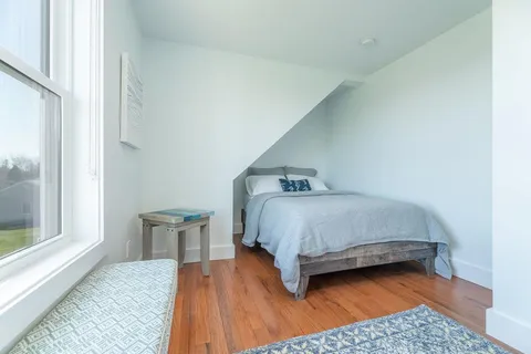 a bedroom with a bed and a wooden floor