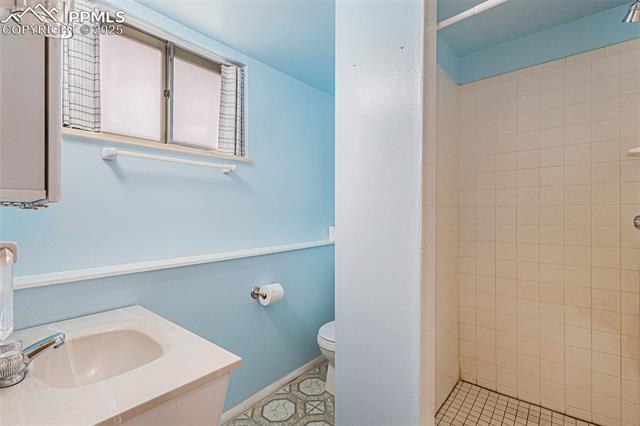 1653 Cragin Road Colorado Springs, CO 80920 - Photo 13 of 27 3/4 bathroom with a shower stall, vanity, and light tile patterned floors