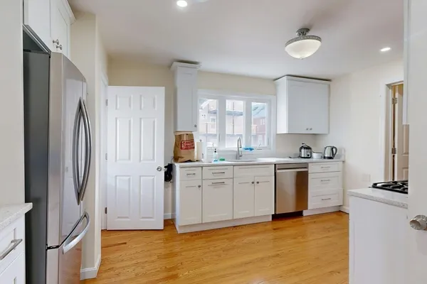 a kitchen with white cabinets and stainless steel appliances