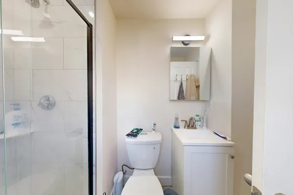 a bathroom with a sink a toilet and shower