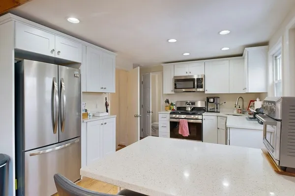 a kitchen with stainless steel appliances granite countertop a refrigerator stove a sink and a microwave