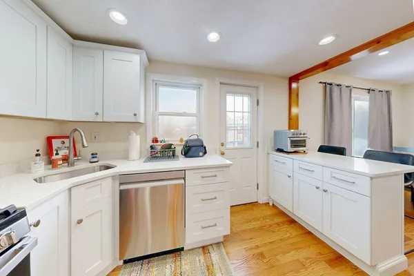 a kitchen with white cabinets appliances and sink