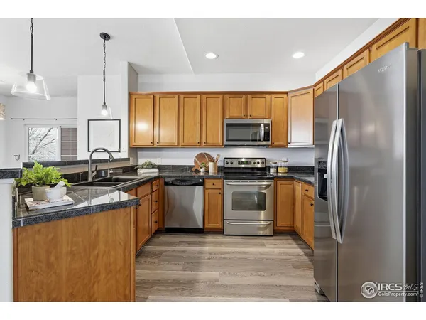 a kitchen with stainless steel appliances granite countertop a refrigerator stove top oven a sink and dishwasher