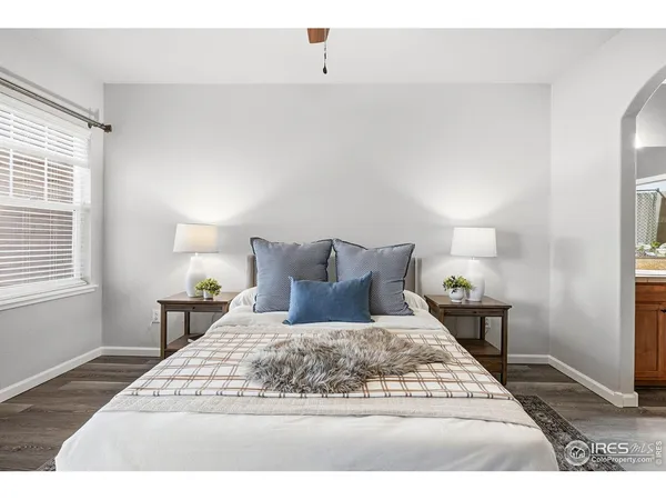 a bedroom with a bed a couch and a potted plant