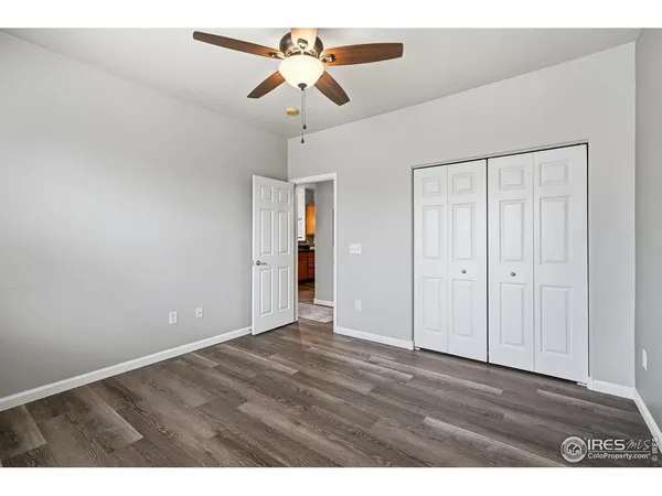 an empty room with windows and ceiling fan