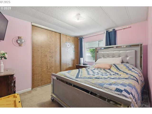 a bedroom with a bed and a dresser with mirror