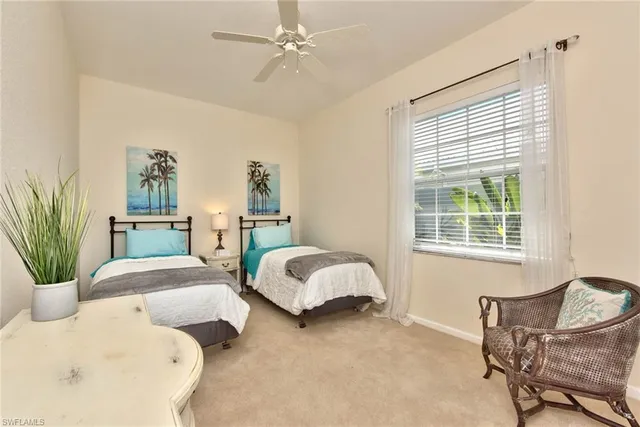 a bedroom with two beds and potted plant