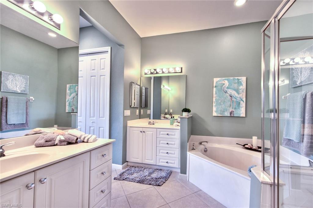 4529 Cardinal Cove Lane, Unit 7 Naples, FL 34114 - Photo 16 of 26 a bathroom with a tub a sink double vanity and glass door