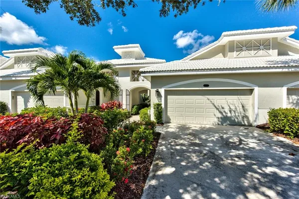 a front view of a house with a yard and potted plants