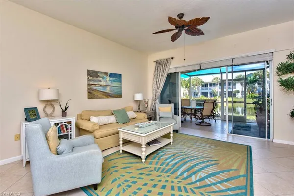 a living room with furniture a flat screen tv and a large window