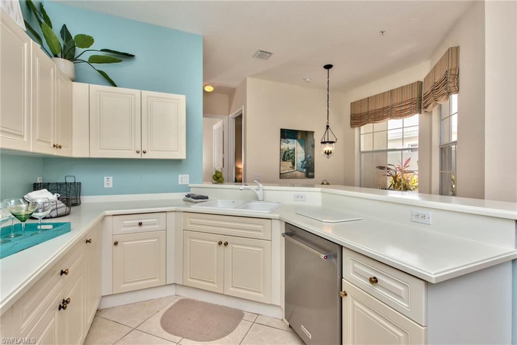 4529 Cardinal Cove Lane, Unit 7 Naples, FL 34114 - Photo 6 of 26 a kitchen with white cabinets and sink