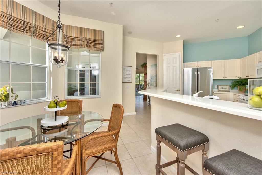 4529 Cardinal Cove Lane, Unit 7 Naples, FL 34114 - Photo 9 of 26 a kitchen with a table chairs and entryway