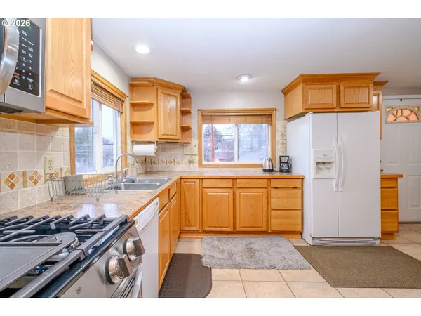 a kitchen with granite countertop a stove a sink and a refrigerator
