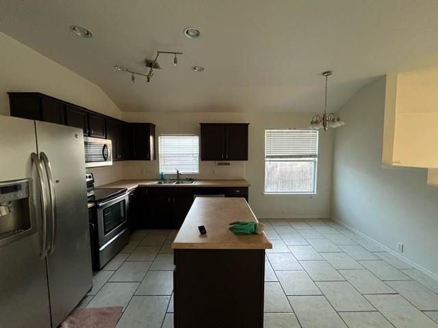 908 Rocking Spur Cove Pflugerville, TX 78660 - Photo 6 of 28 a kitchen with granite countertop a refrigerator and a stove top oven