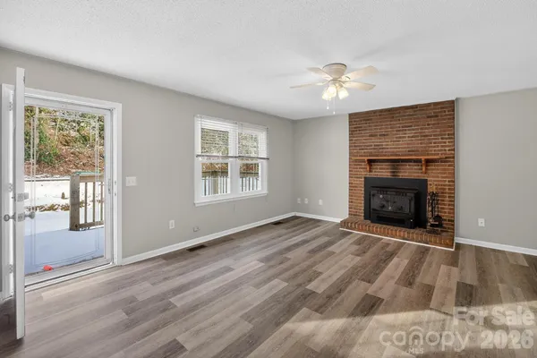 wooden floor fireplace and windows in an empty room