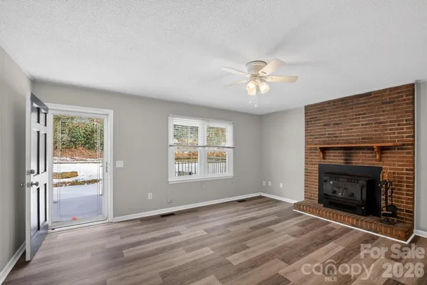 an empty room with windows and a fireplace