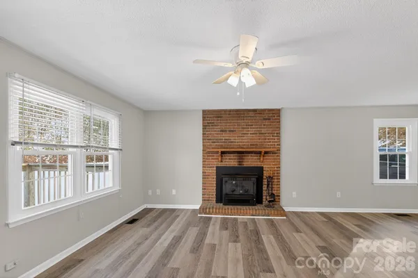 an empty room with windows and fireplace