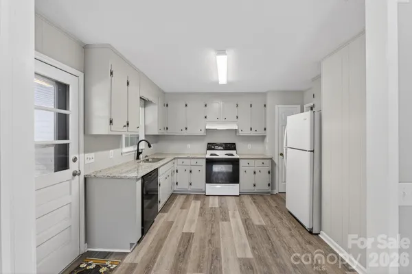 a kitchen with a sink a counter top space stainless steel appliances and cabinets