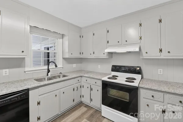 a kitchen with granite countertop white cabinets and white appliances