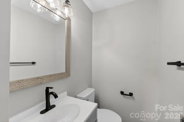 a bathroom with a toilet a sink and a mirror