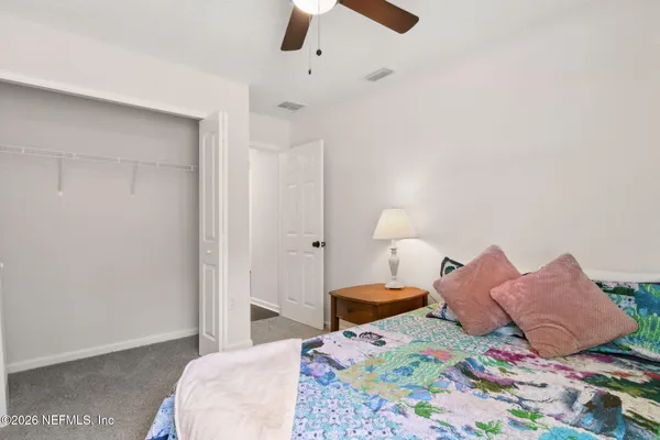 a bedroom with a bed and a painting on the wall