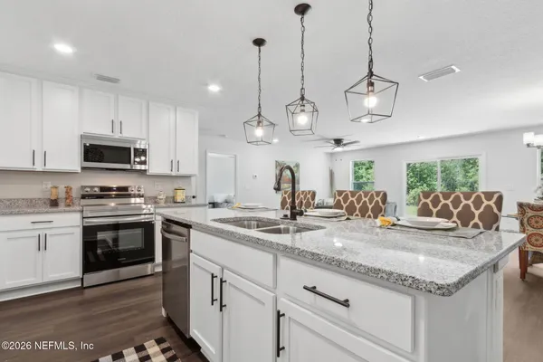 a kitchen with kitchen island granite countertop stainless steel appliances a sink and stove