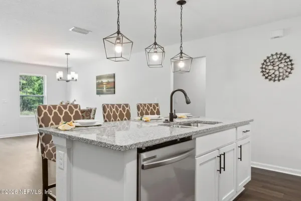 a kitchen with a sink cabinets and wooden floor