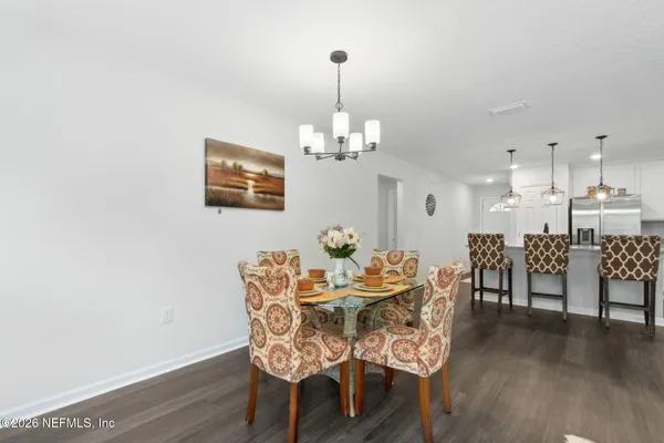 a dining room with furniture wooden floor a rug and a chandelier