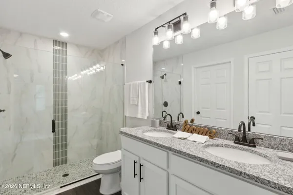 a bathroom with a granite countertop sink toilet and shower