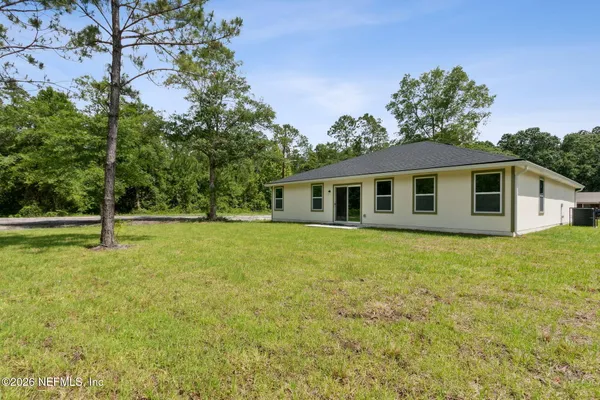 a view of a house with backyard and tree
