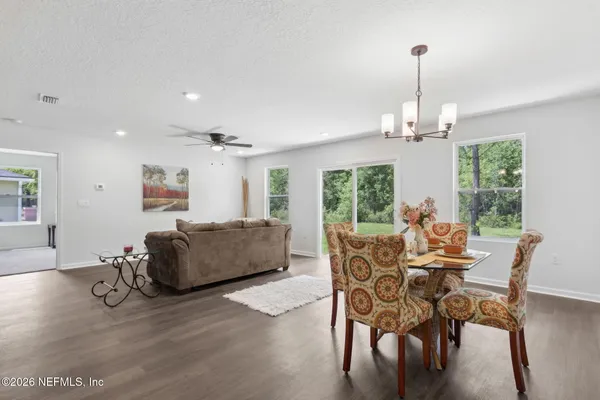 a dining room with furniture a chandelier and wooden floor