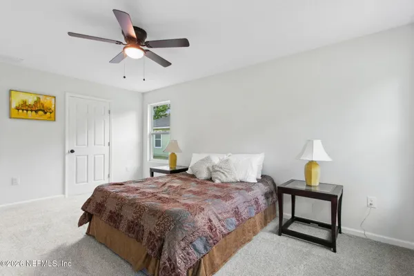 a bedroom with a bed a dresser and a window