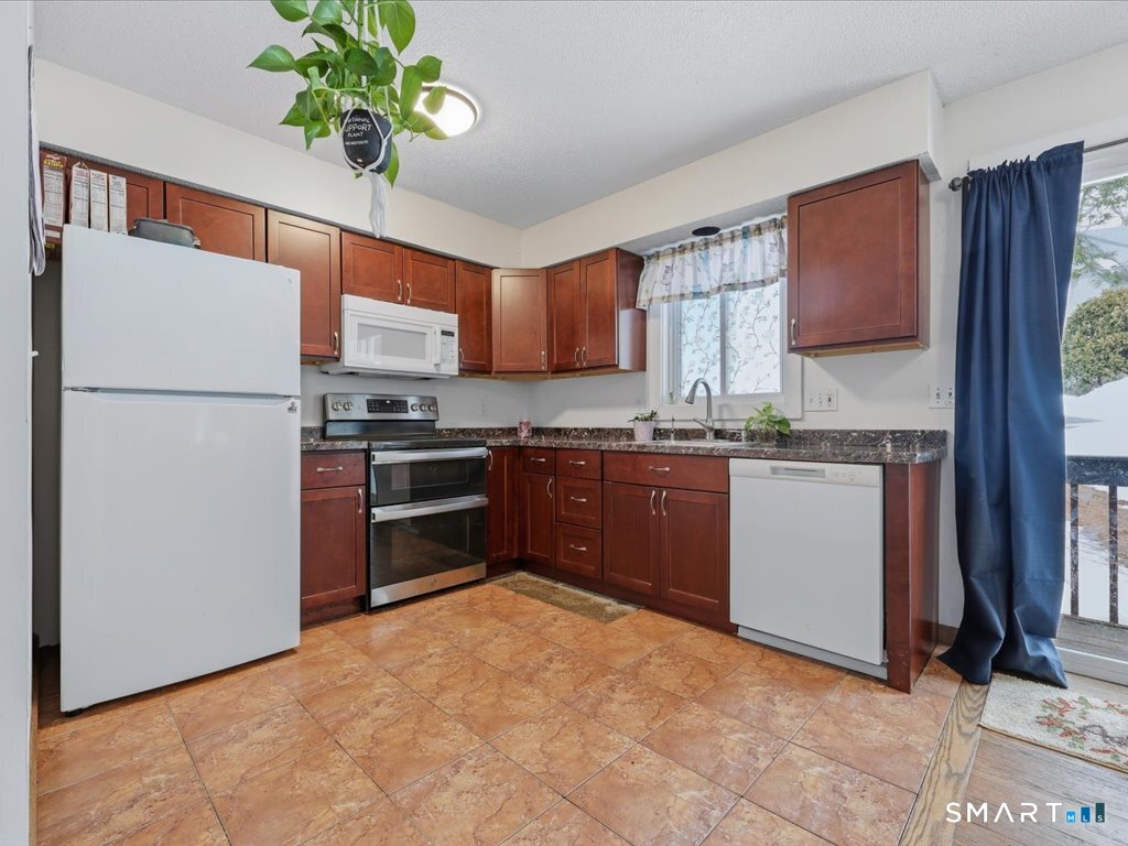 78 Woodland Ridge Meriden, CT 06450 - Photo 5 of 24 a kitchen with stainless steel appliances granite countertop a refrigerator a sink a stove a microwave a washer and dryer