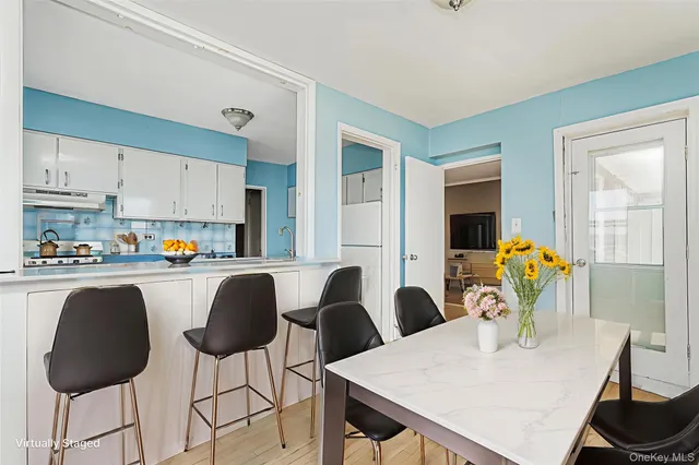 a kitchen with stainless steel appliances granite countertop a table chairs and a refrigerator