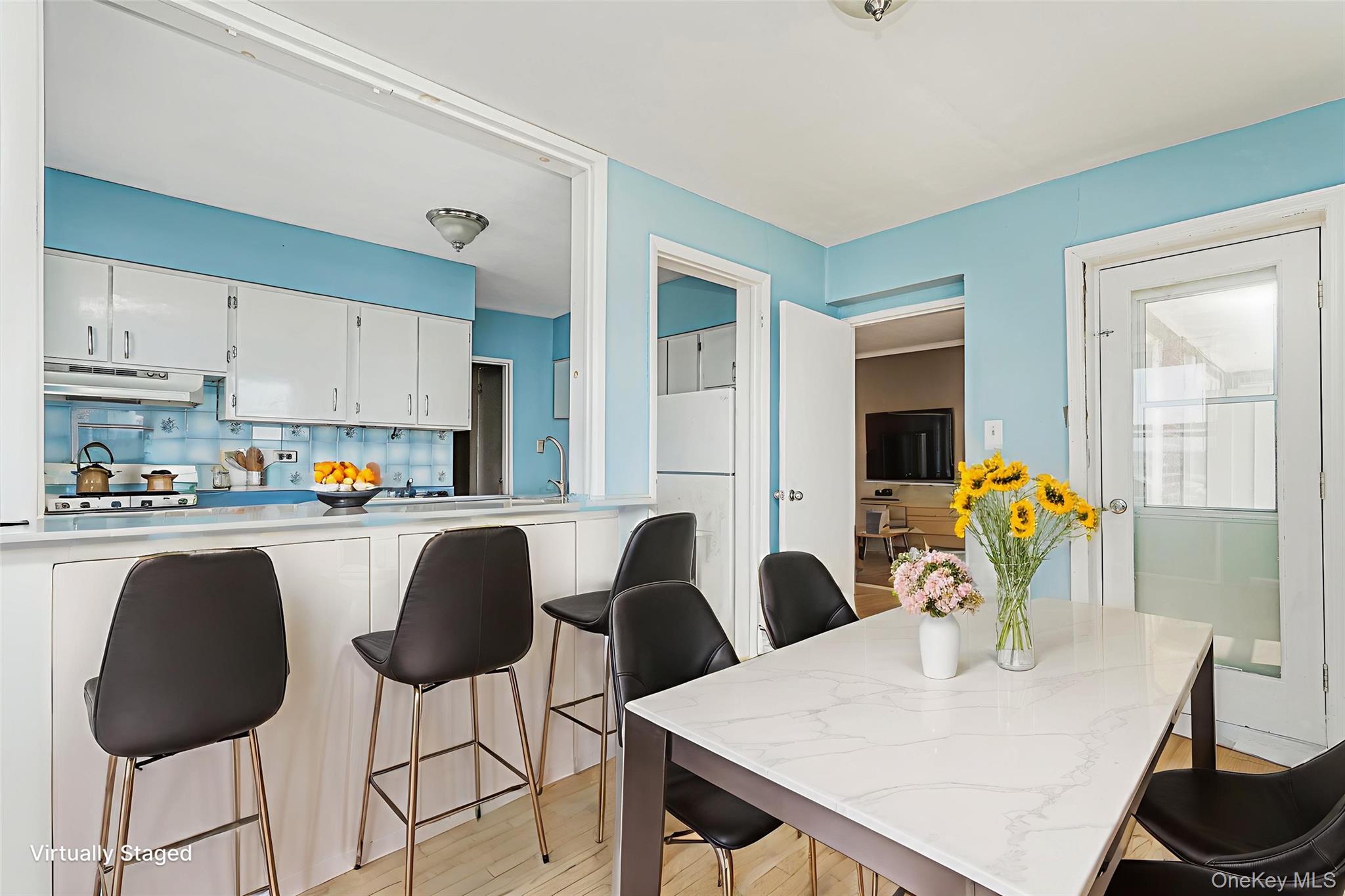 125 Beach 124th Street, Unit 6H Queens, NY 11694 - Photo 13 of 27 a kitchen with stainless steel appliances granite countertop a table chairs and a refrigerator