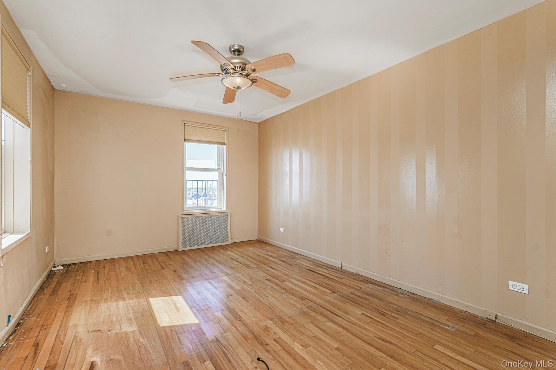 125 Beach 124th Street, Unit 6H Queens, NY 11694 - Photo 17 of 27 a view of an empty room with wooden floor and a window