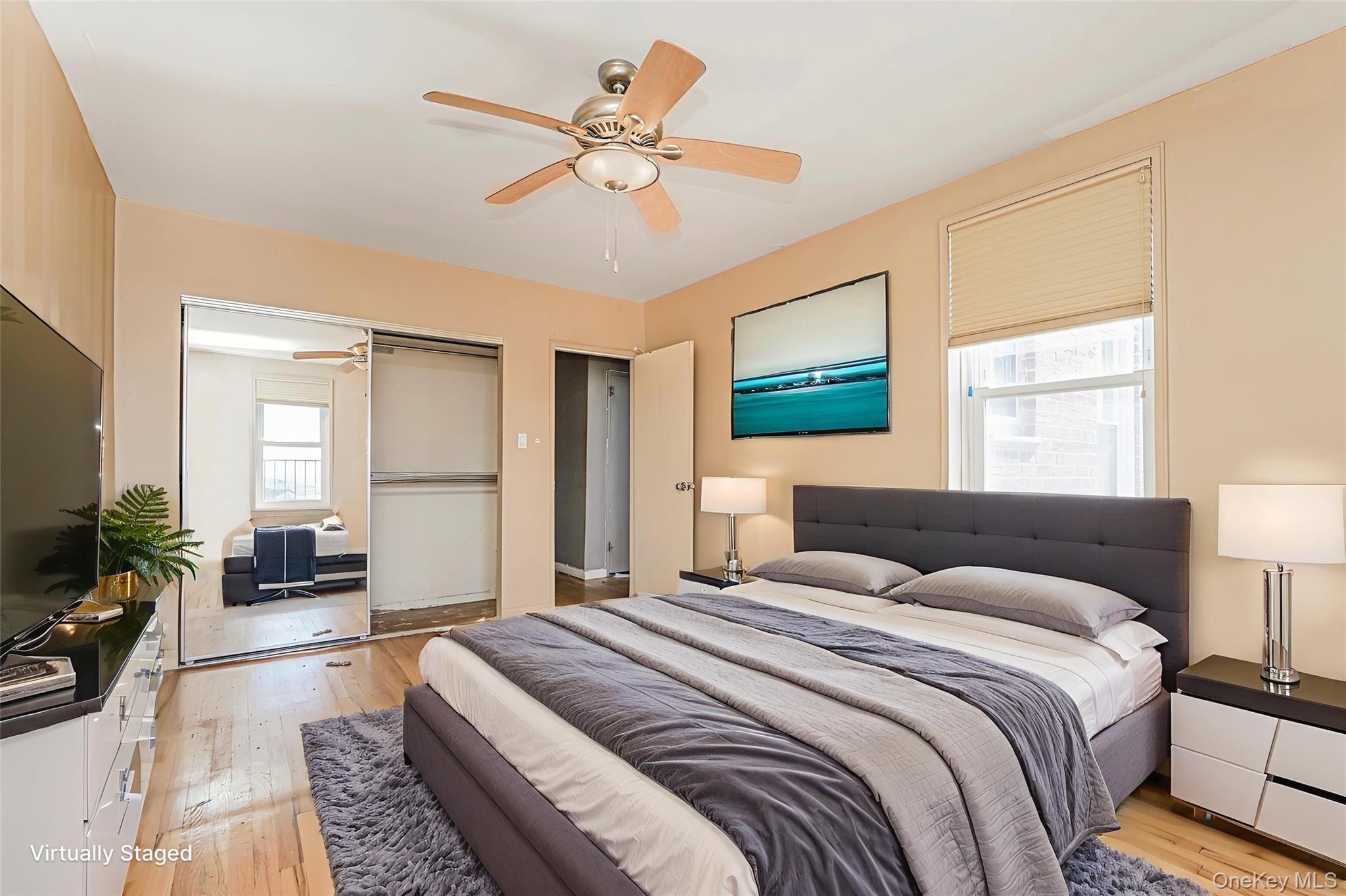 125 Beach 124th Street, Unit 6H Queens, NY 11694 - Photo 20 of 27 a bedroom with a large bed a flat screen tv and a couch