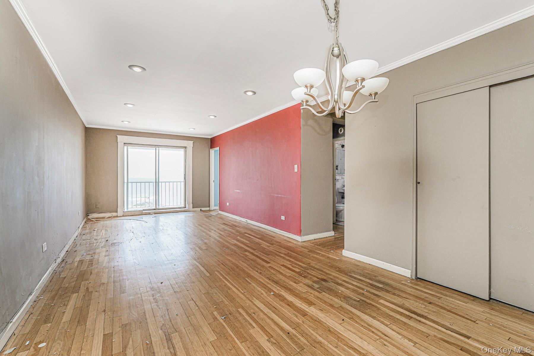 125 Beach 124th Street, Unit 6H Queens, NY 11694 - Photo 6 of 27 a view of an empty room with wooden floor and a window