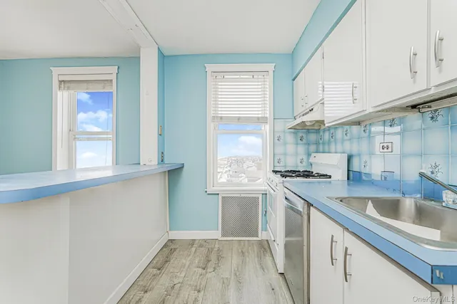 a kitchen with granite countertop a sink a counter space appliances and cabinets