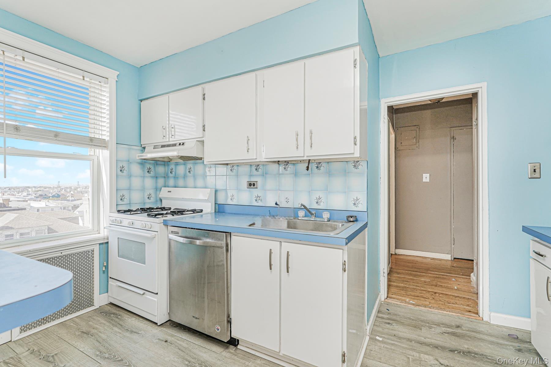125 Beach 124th Street, Unit 6H Queens, NY 11694 - Photo 9 of 27 a kitchen with cabinets appliances and a wooden floor