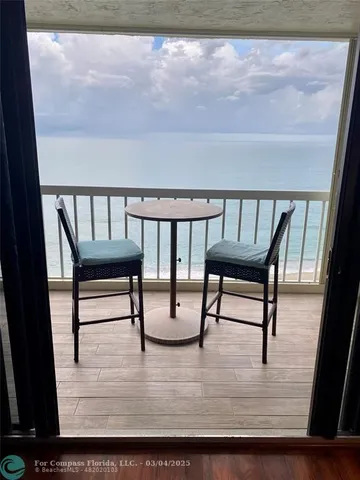 a view of chairs and a table in wooden floor