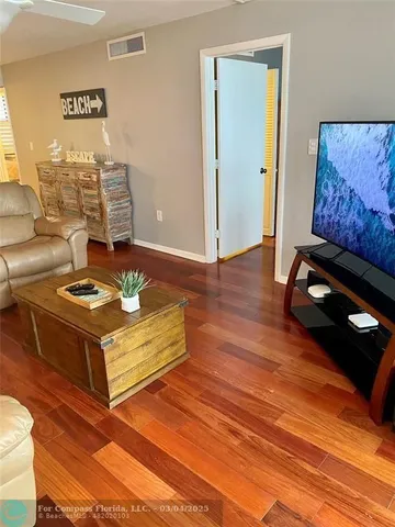 a bed sitting in a bedroom next to a window with wooden floor