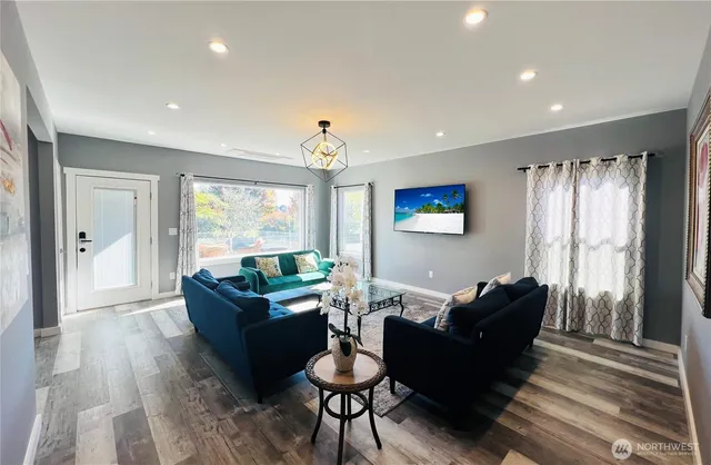 a bedroom with a bed a desk and chair with wooden floor