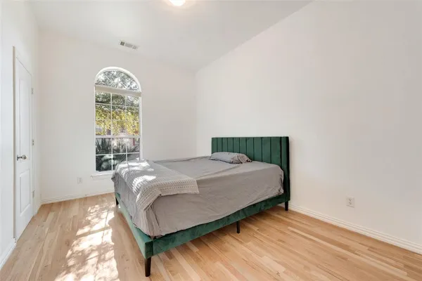 a bedroom with a bed mirror and window