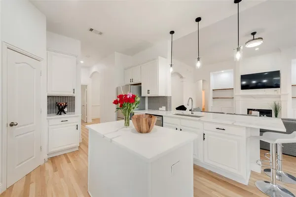 a kitchen with a sink a refrigerator a stove and white cabinets