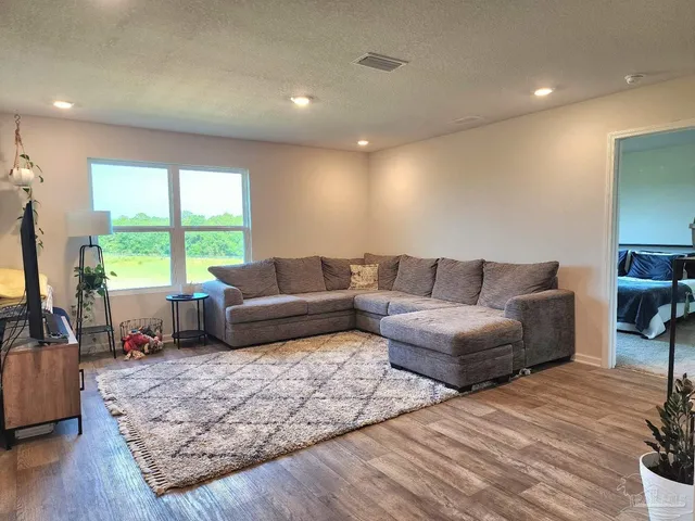 a living room with furniture window and a wooden floor