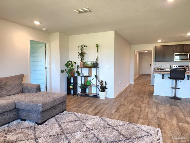a living room with furniture and wooden floor