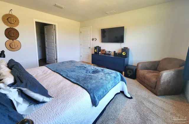 a bedroom with a bed and a television